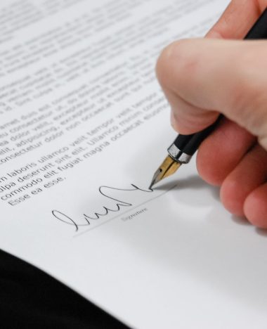 Close-up of a hand signing a separation agreement document with a fountain pen
